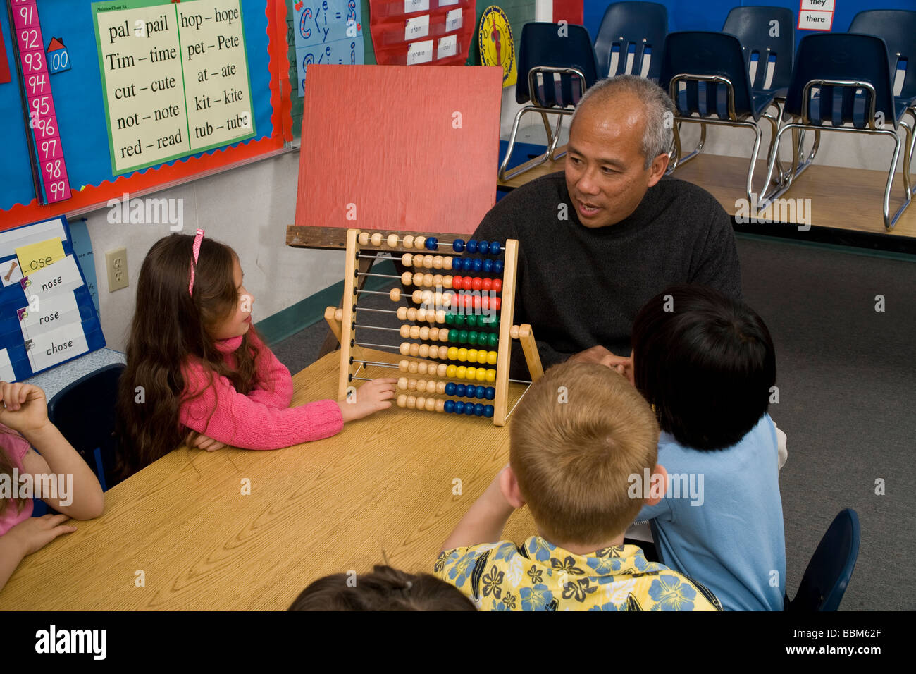 5-6 Jahre alten Studenten ethnischer inter ethnische Vielfalt rassisch verschiedenen multikulturellen interracial Filipino Freiwilligen zählen Abacus POV-USA Stockfoto