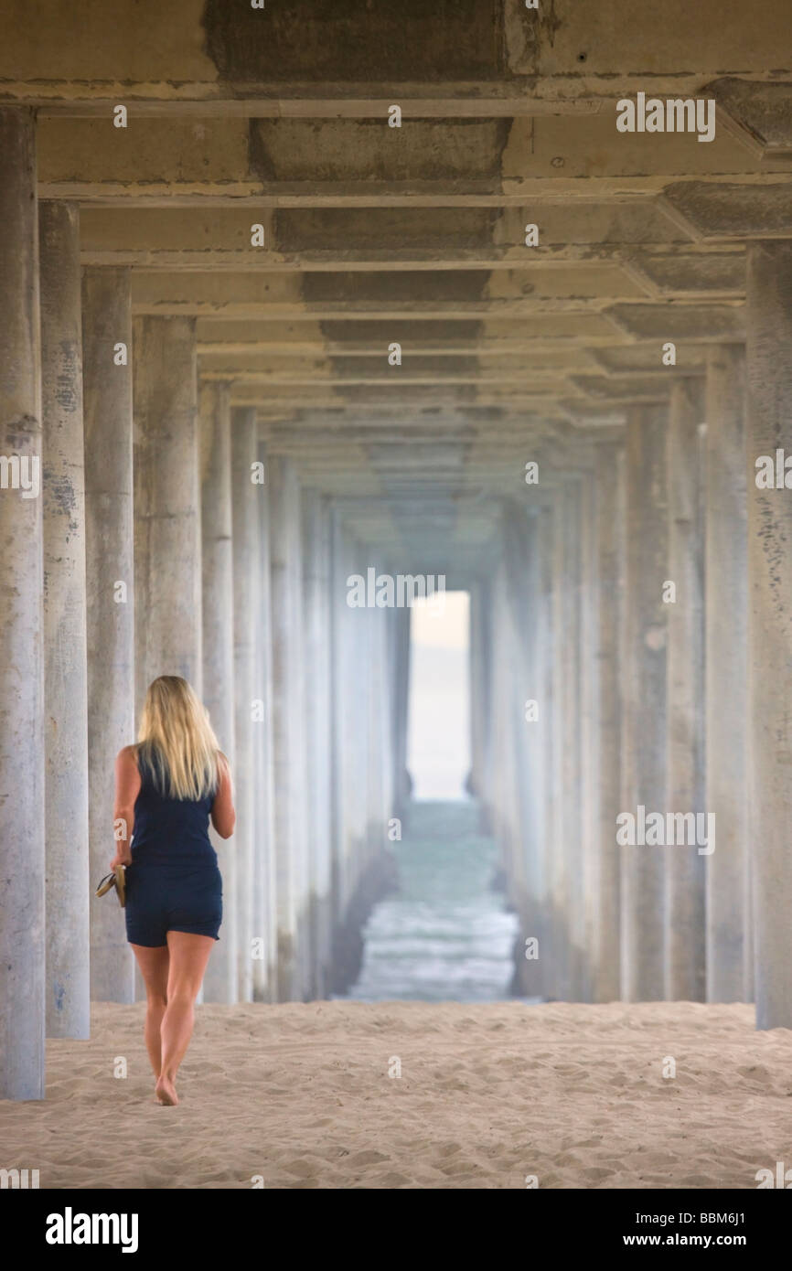 Frau zu Fuß unter dem Pier Huntington Beach Orange County in Kalifornien Stockfoto