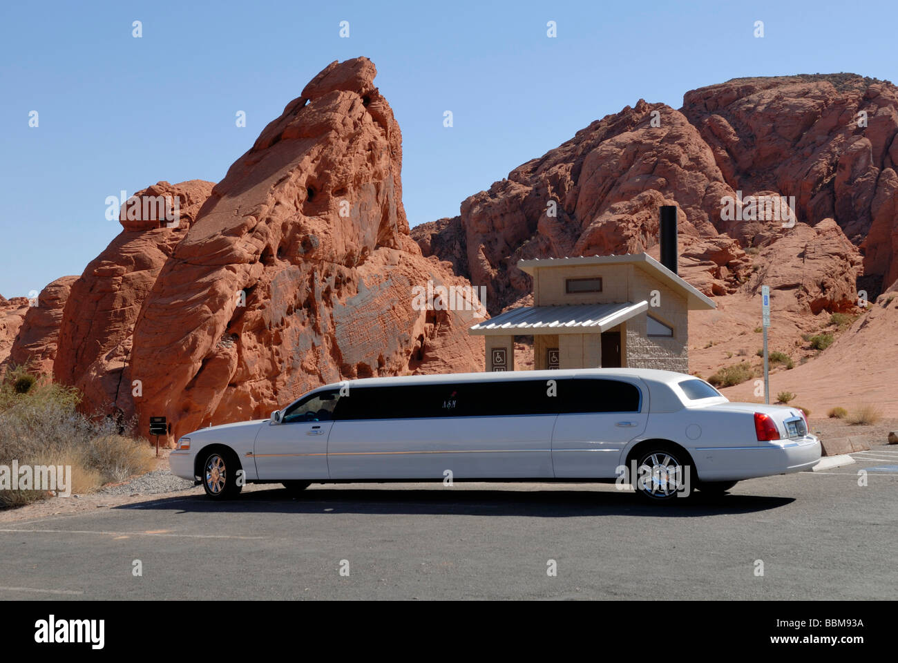 Luxus-Auto vor einer Toilette Hütte, Rainbow Vista, Tal des Feuers Staatspark, Nevada, USA Stockfoto