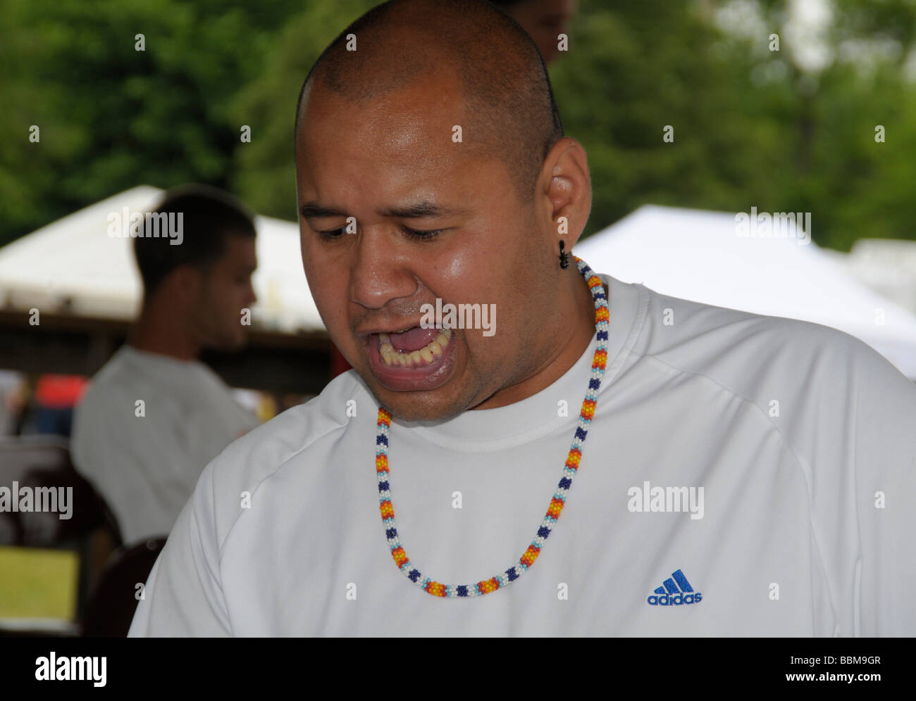 Ein Indianer vom Stamm Cherokee lässt einen indischen Schrei beim schlagen der Trommeln zu einem Pow Wow InWaldorf, Maryland Stockfoto