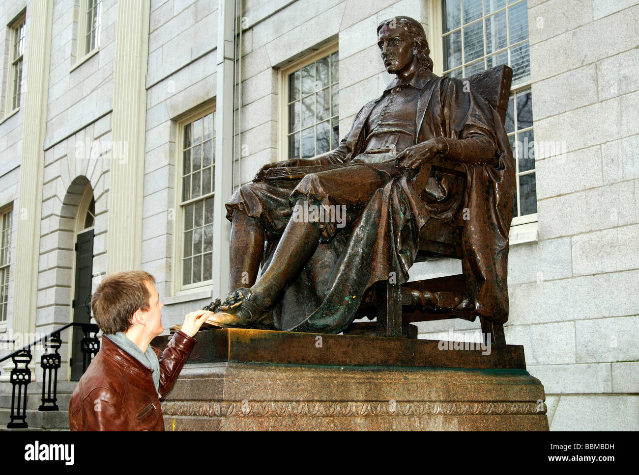 Student an der Statue von John Harvard von Daniel Chester French, die Berührung des Schuhs Glück bei den Prüfungen, Harvard University bringen. Stockfoto