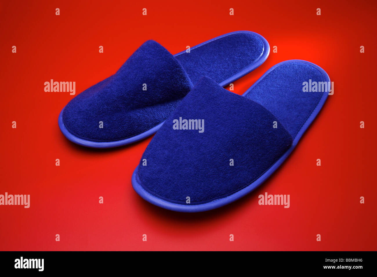 Blaue Pantoffeln auf rotem Grund Stockfoto