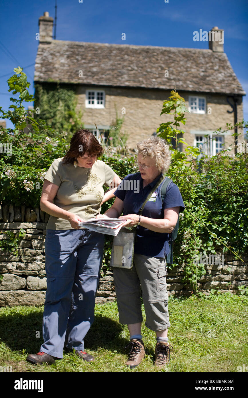 Cotswold Gefängniswärter und einen Blick auf eine Karte in den Cotswolds AONB walker Stockfoto