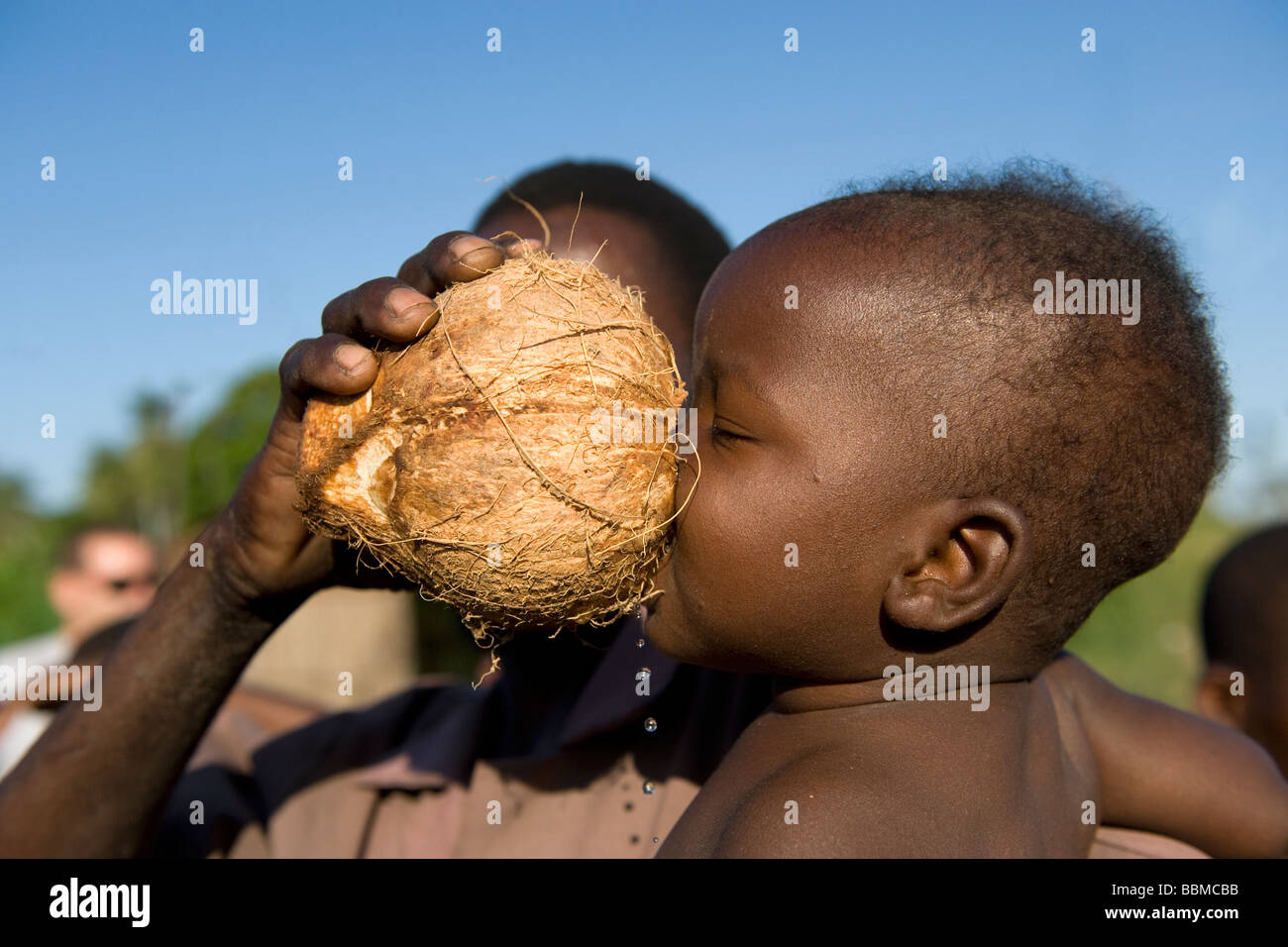Kind trinkt frische Kokosnussmilch Quelimane Mosambik Stockfoto