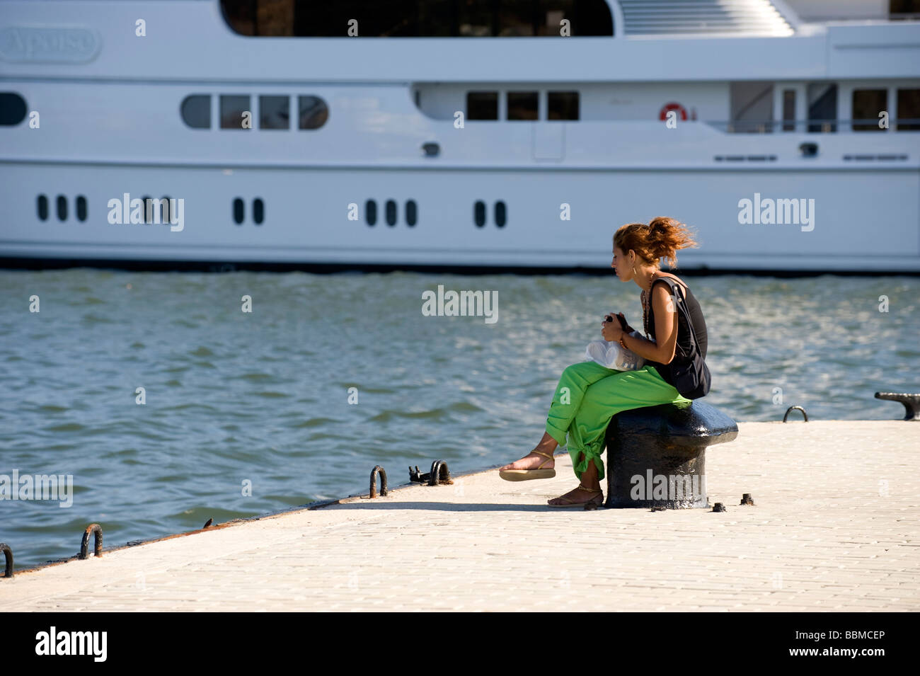 Mädchen sitzen auf einem Pfosten festmachen im Hafen Havanna Stockfoto