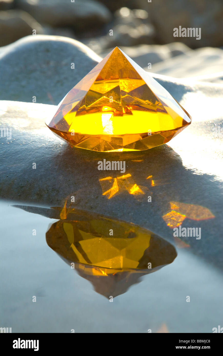 Amber Glaspyramide auf Felsen mit Meerwasser-pool Stockfoto