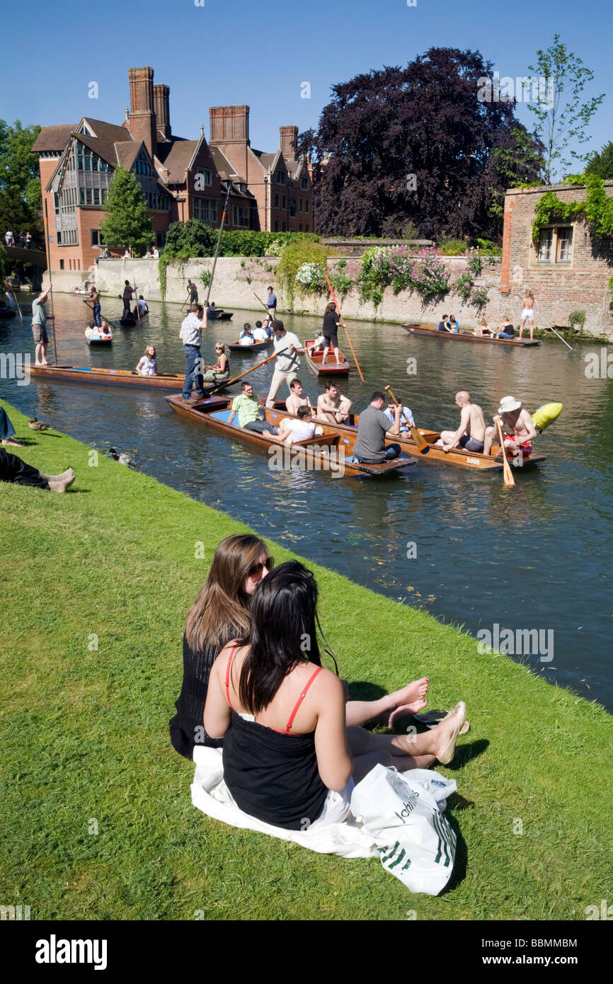 Menschen sitzen am Ufer des Flusses Cam am Clare College in Cambridge, beobachten die Stechkahn fahren an einem Sommertag Stockfoto