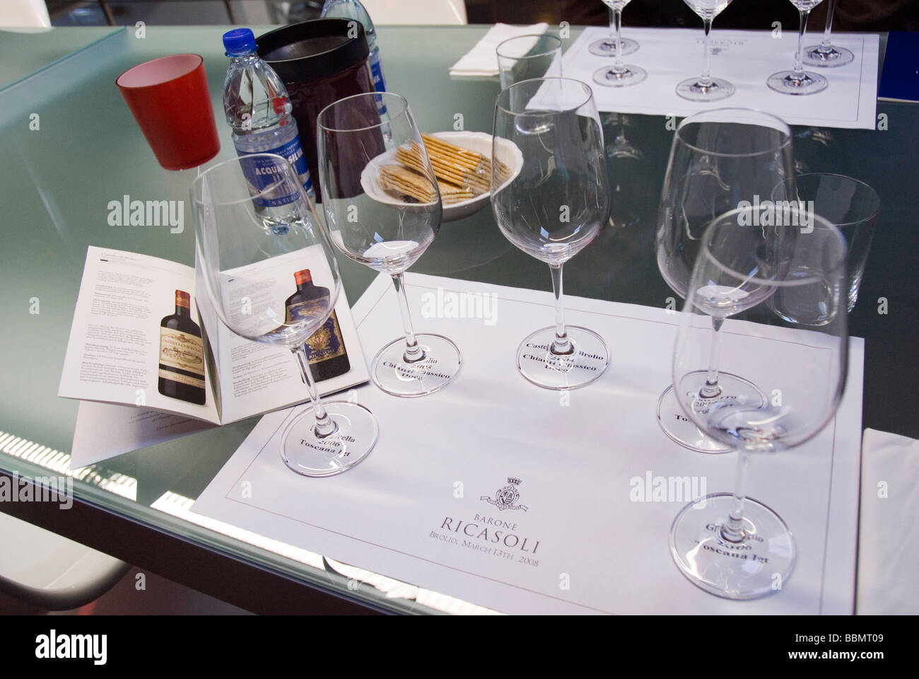 Flaschen und Gläser nehmen ihren Platz auf einer speziell markierten Ort Matte bei einer Weinprobe im Castello Brolio im Chianti Stockfoto