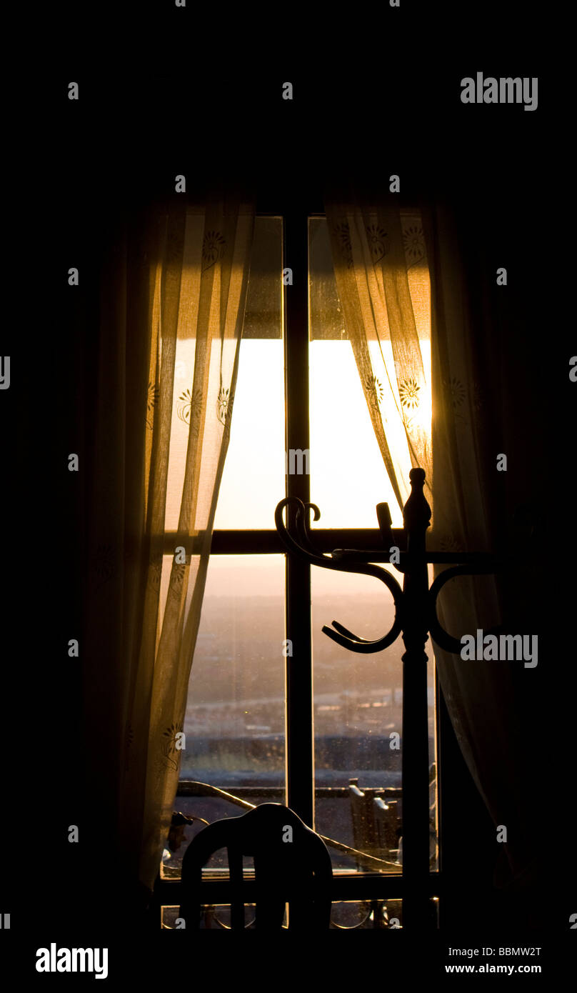 Sonnenuntergang über Fenster erfüllten Stuhl und Mantel stand Stockfoto