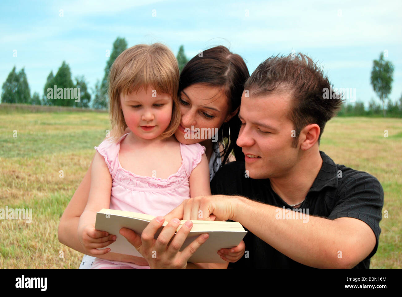 Familienglück, Mutter, Vater und Kind gemeinsam ein Buch zu lesen Stockfoto