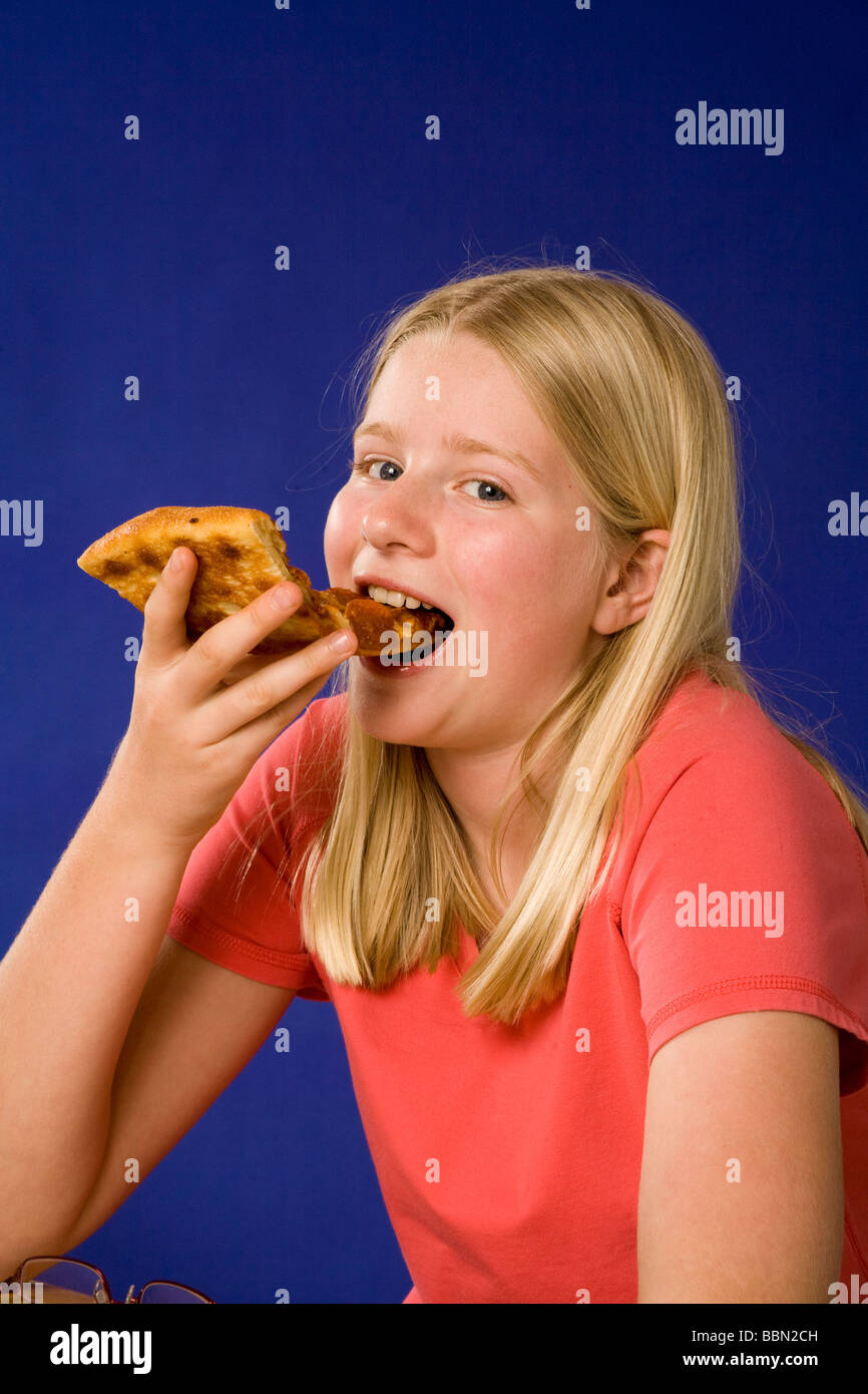 Porträt eines Mädchens Essen Stück Pizza, Studio gedreht ausgeschnitten Herr © Myrleen Pearson Stockfoto