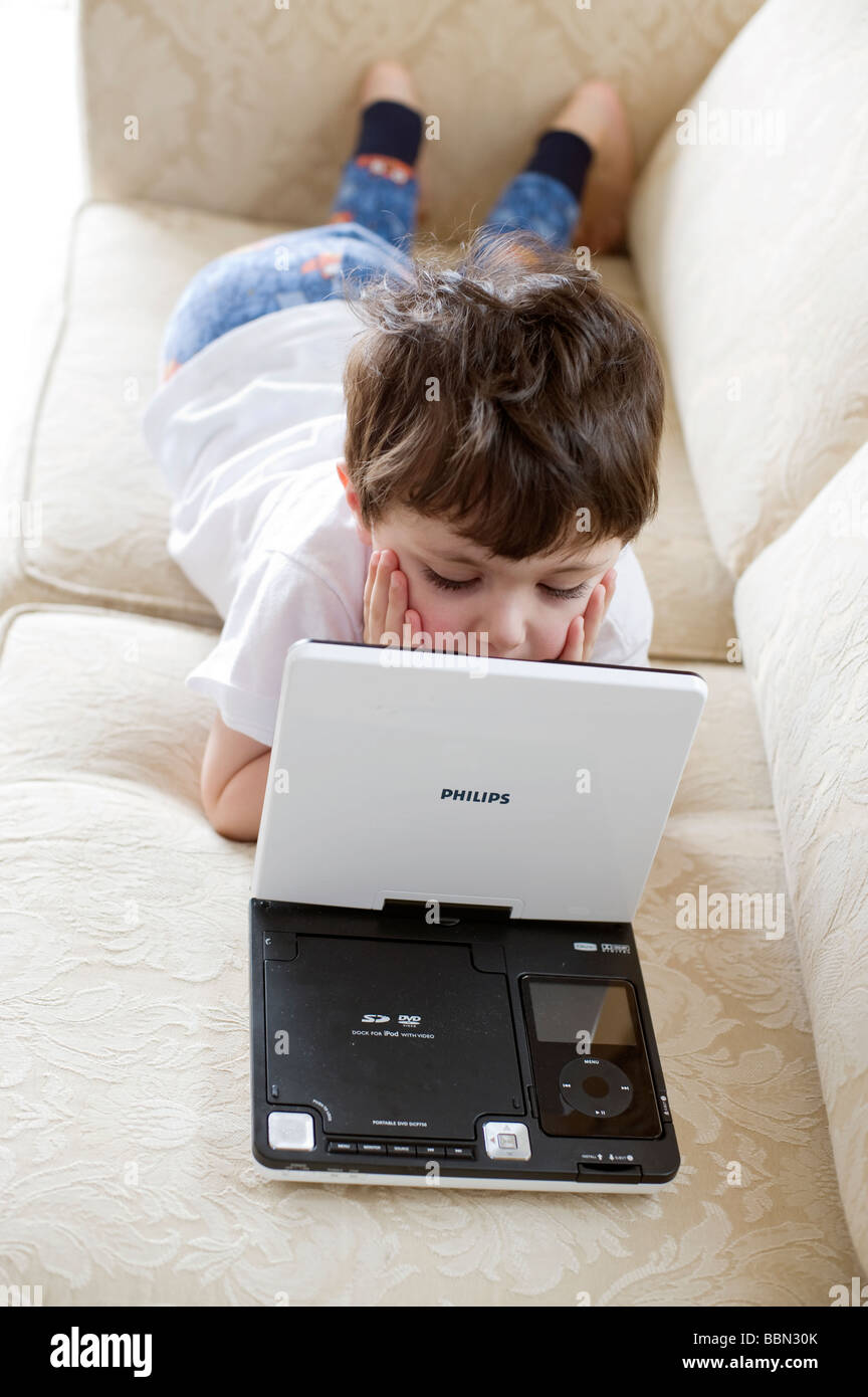 Drei Jahre Alter spanischer Junge fasziniert durch eine "Wackelt" DVD- Wiedergabe auf einem tragbaren DVD-player Stockfotografie - Alamy