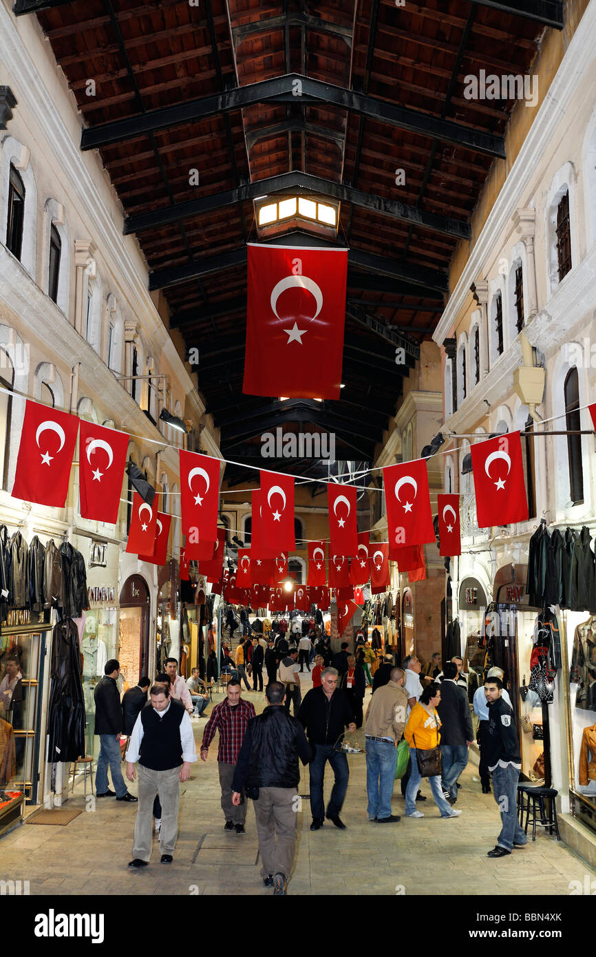 Überdachte Gasse mit Geschäften, überfüllt mit Menschen, hängen Türkische Flaggen, Kapali Carsi Basar, Istanbul, Türkei Stockfoto