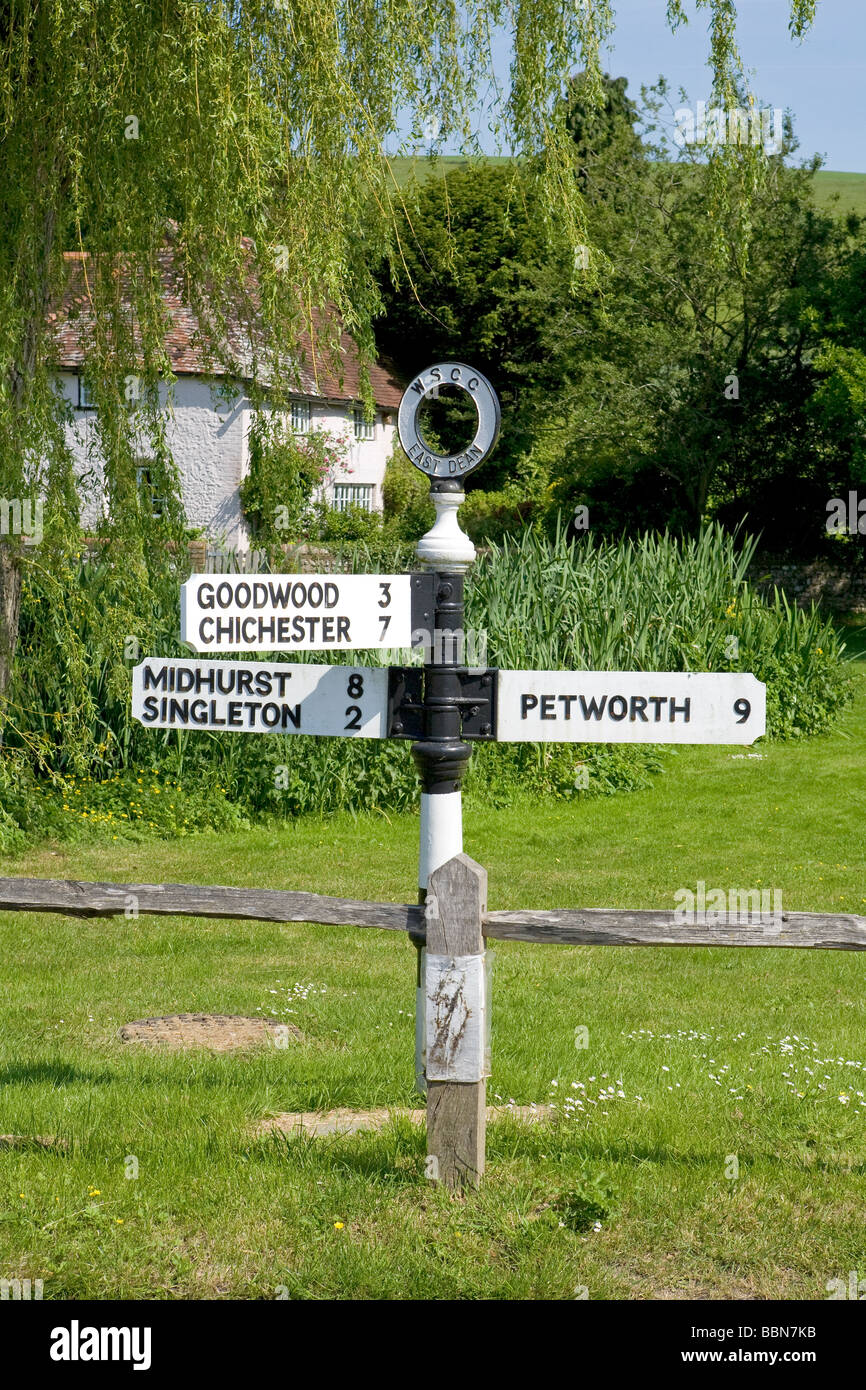 Lokale Straße, Kilometerstand und Wegweiser bei East Dean Village, West Sussex, Großbritannien Stockfoto