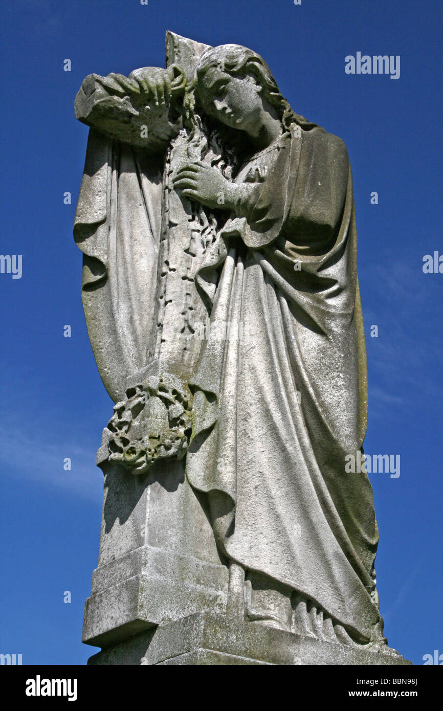 Grabstein Engel hält Kreuz im Flaybrick Memorial Friedhof Gärten, Bidston Hill, Wirral, Merseyside, England, UK Stockfoto