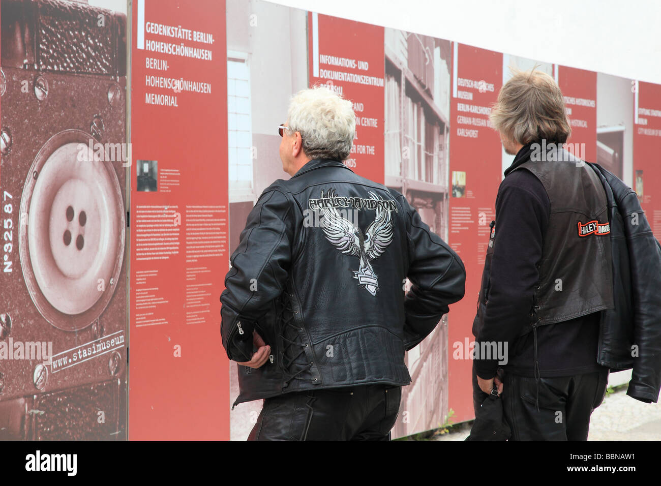 Zwei Mann mit Harley Davidson Jacken mit Blick auf die Bilder der Ausstellung im Check Point Charlie Berlin Deutschland Europa Stockfoto