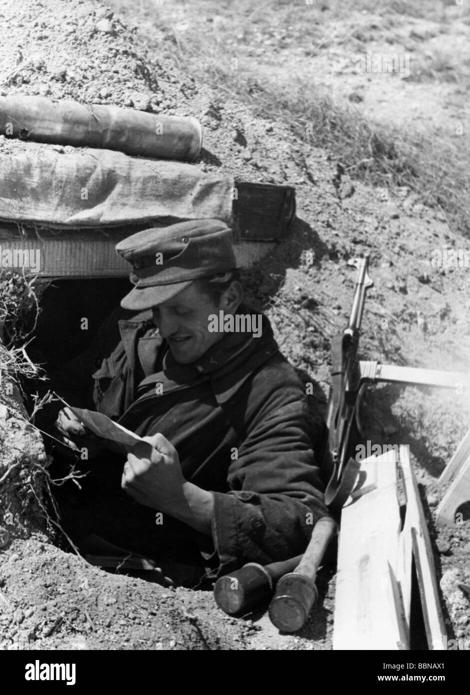 Ereignisse, Zweiter Weltkrieg/Zweiter Weltkrieg, Russland 1944/1945, Krim, deutscher Soldat in einem Foxloch, Lesen eines Briefes, in der Nähe von Sewastopol, April 1944, 20. Jahrhundert, historische, historische, Ostfront, UdSSR, Sowjetunion, Ukraine, Wehrmacht, Luftwaffe, MP 40 Untermaschinengewehr, Handgranaten, Feldkappe, Schutz, lächelndes Militär, Drittes Reich, Soldaten, vierziger Jahre, Personen, Stockfoto