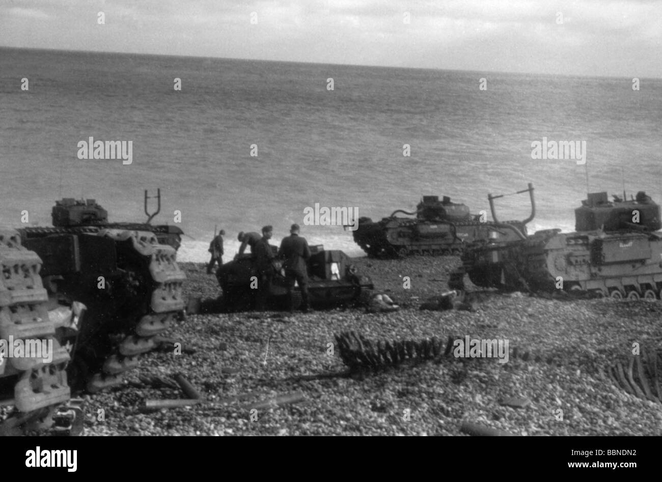 Ereignisse, Zweiter Weltkrieg/Zweiter Weltkrieg, Frankreich, Dieppe, 19.8.1942, zerstörte gepanzerte Fahrzeuge des 14. Kanadischen Armee-Panzer-Regiments (Calgary Tanks) am Strand, deutsche Soldaten untersuchen einen Bren Gun Carrier, Stockfoto