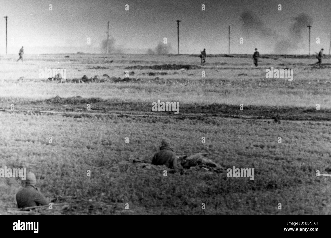 Ereignisse, Zweiter Weltkrieg / Zweiter Weltkrieg, Russland 1942 / 1943, deutsche Soldaten auf einem Feld, im Hintergrund explodierende sowjetischen Artillerie-Granaten, Sommer/Herbst 1943, Stockfoto
