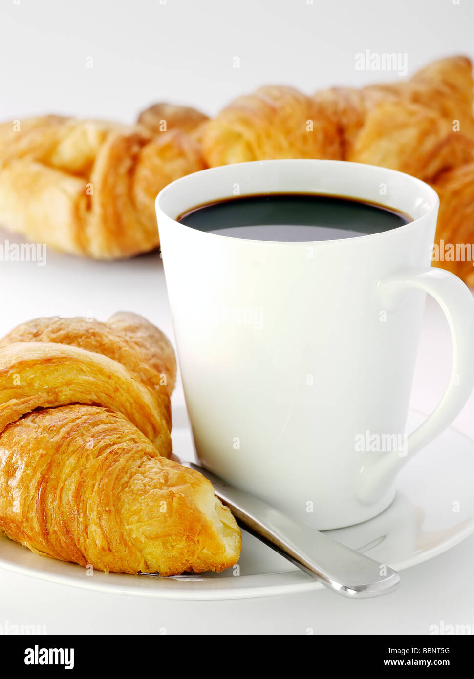 eine Tasse schwarzen Kaffee mit frischen croissants Stockfoto