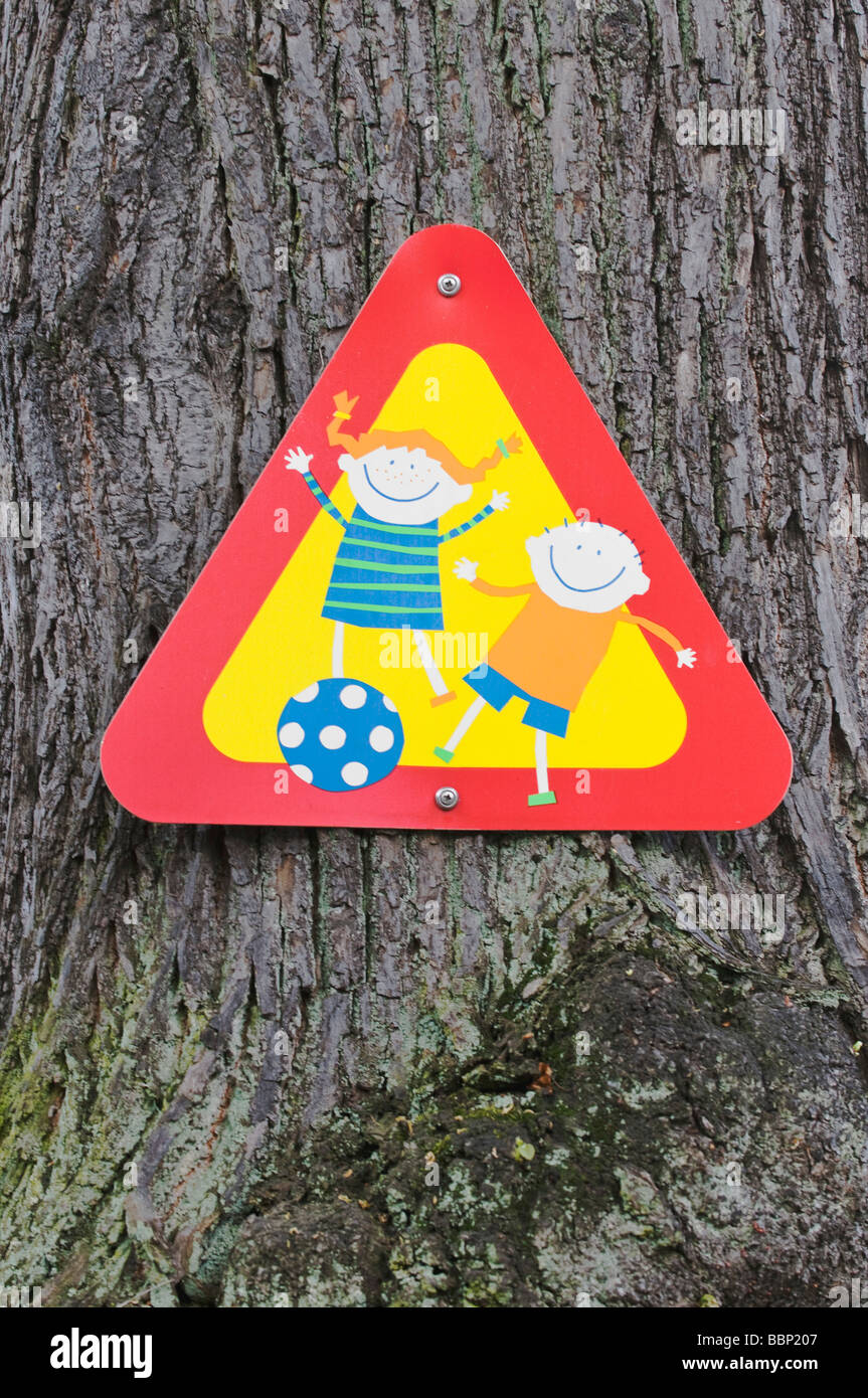 Unterzeichnen Sie, Achtung, spielende Kinder, auf Baumstamm Stockfotografie  - Alamy