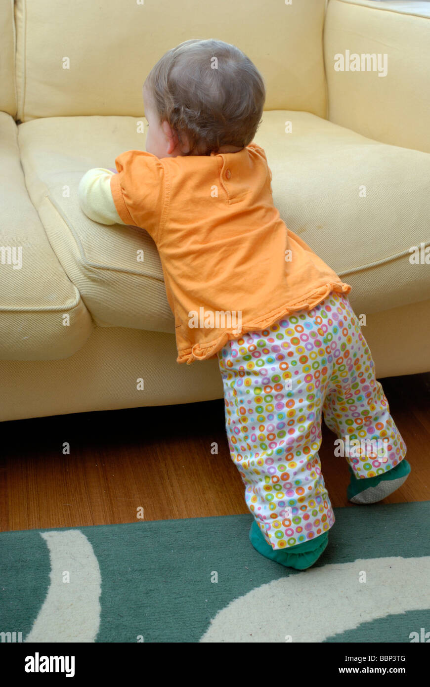 Zehn Monate altes Baby zog sich bis zu stehen Stockfoto