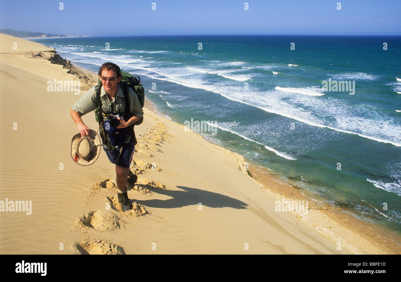 Männlichen kaukasischen Wanderer zu Fuß auf einer Sanddüne in der Alexandria-Duneveld mit dem indischen Ozean im Hintergrund, Südafrika Stockfoto