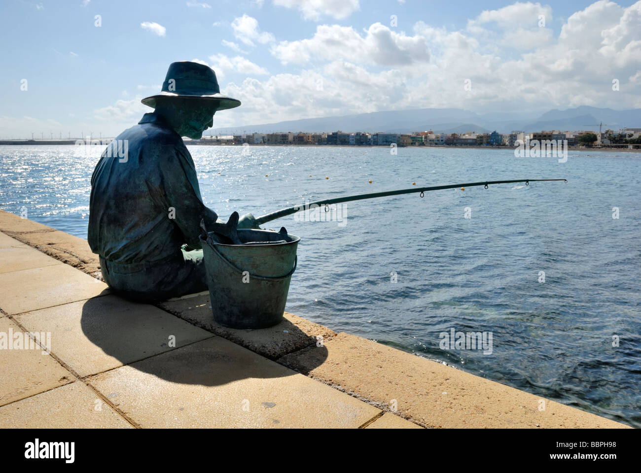 Eine Skulptur eines Fischers in der Pier von der kleinen Küstenstadt von Arinaga. Arinaga, Gran Canaria, Kanarische Inseln, Spanien, EU. Stockfoto