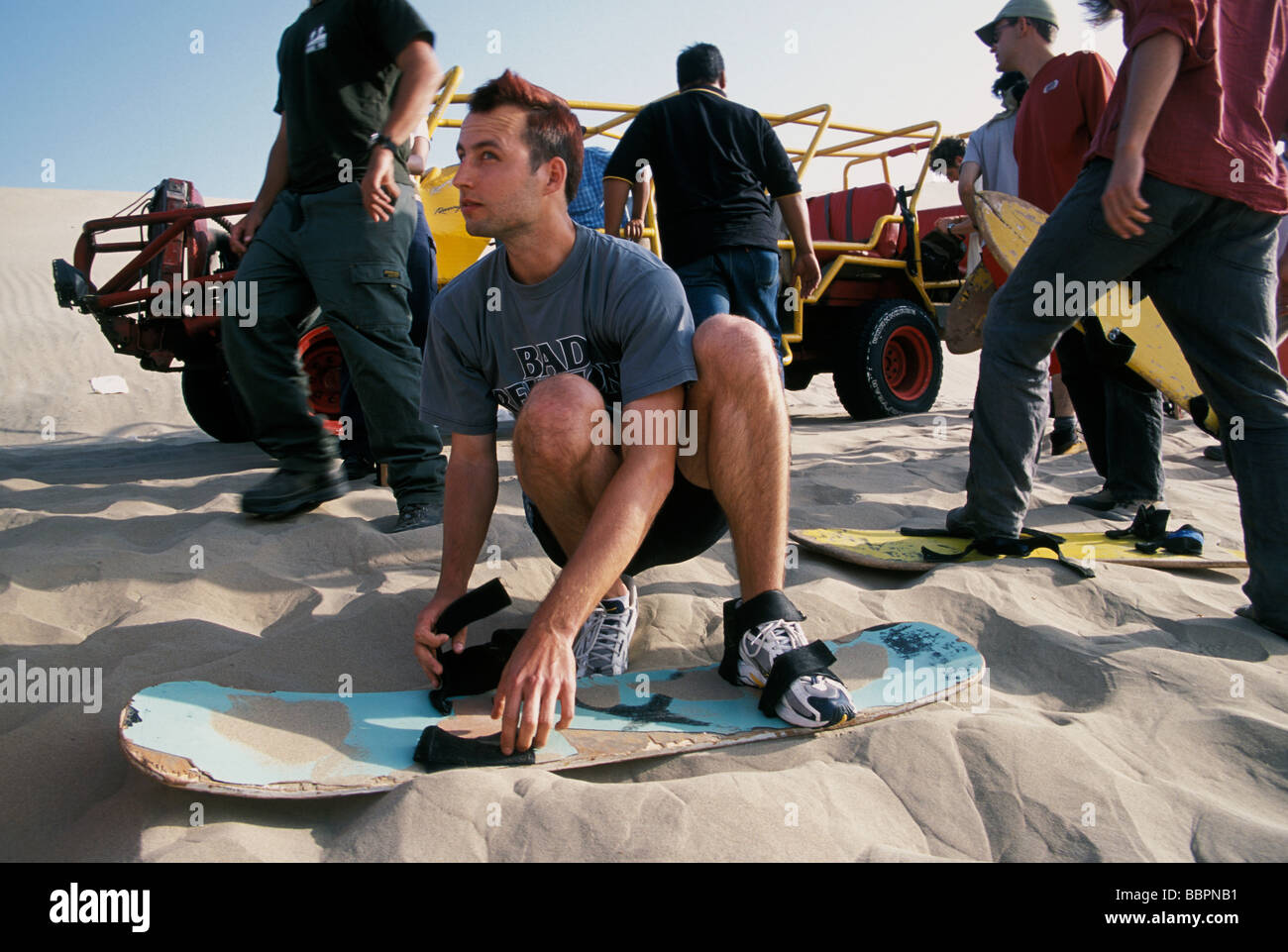 Junge europäische Reisende ausprobieren Sand boarding in den Sanddünen von Huacachina Peru Stockfoto