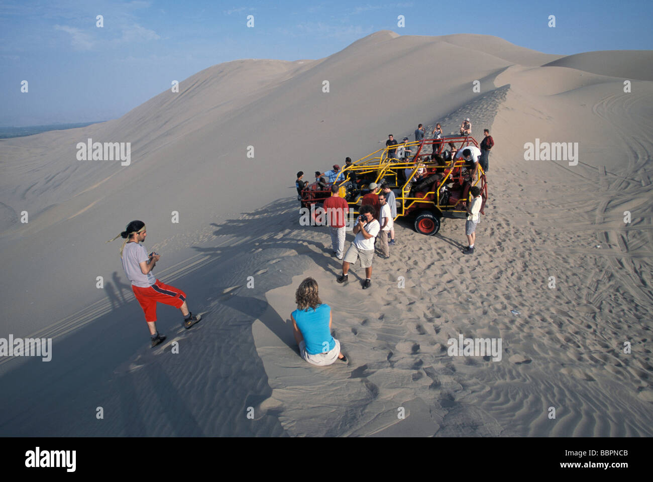 Junge europäische Reisende ausprobieren Sand boarding in den Sanddünen von Huacachina Peru Stockfoto