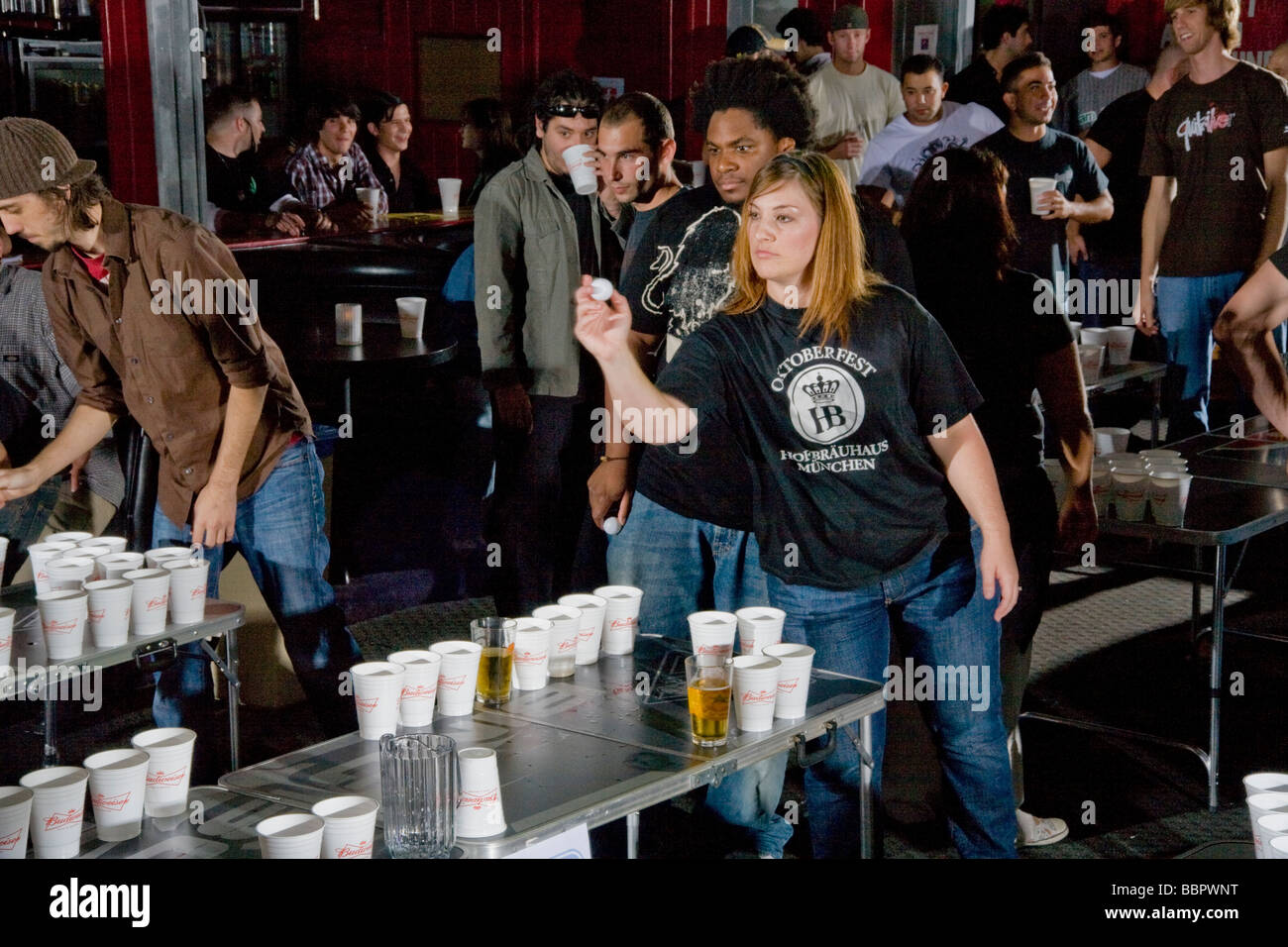 Als ihrer Teamkollegin eine Spielerin Uhren bereitet, einen Ping-Pong-Ball während einer Bier-Pong-Wettbewerb in Los Angeles zu werfen Stockfoto