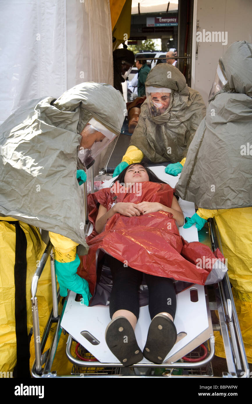 Personal in Schutzkleidung sorgen für ein freiwilliges Opfer simulieren die Nachwirkungen eines chemischen biologischen Angriffs Stockfoto