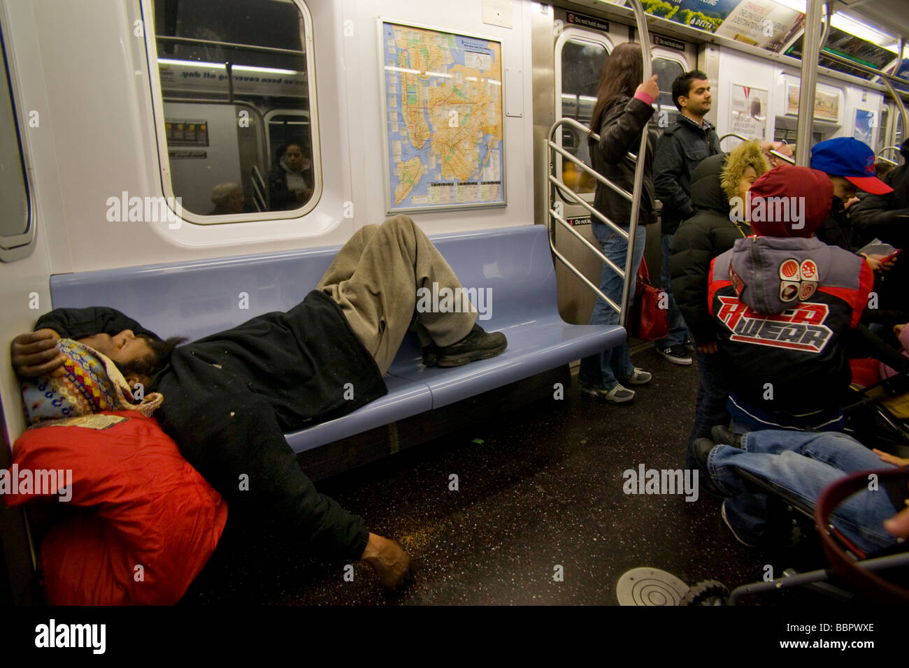 Ein Obdachloser schläft auf einem u-Bahn-Sitz in New York City beachten Sie andere Passagiere Gleichgültigkeit Stockfoto