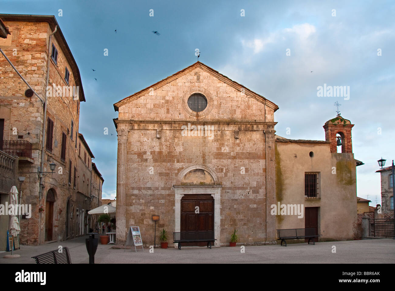 Mauersegler und Schwalben fliegen über den Dom in Magliano in Toscana Stockfoto