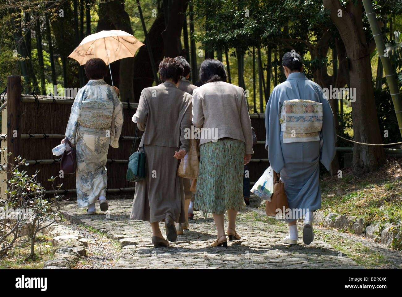 Eine Gruppe von Mitte japanischen Frauen im Alter von einigen tragen Kimono, ein Spaziergang durch einen Garten in Hamamatsu Schlosspark Stockfoto