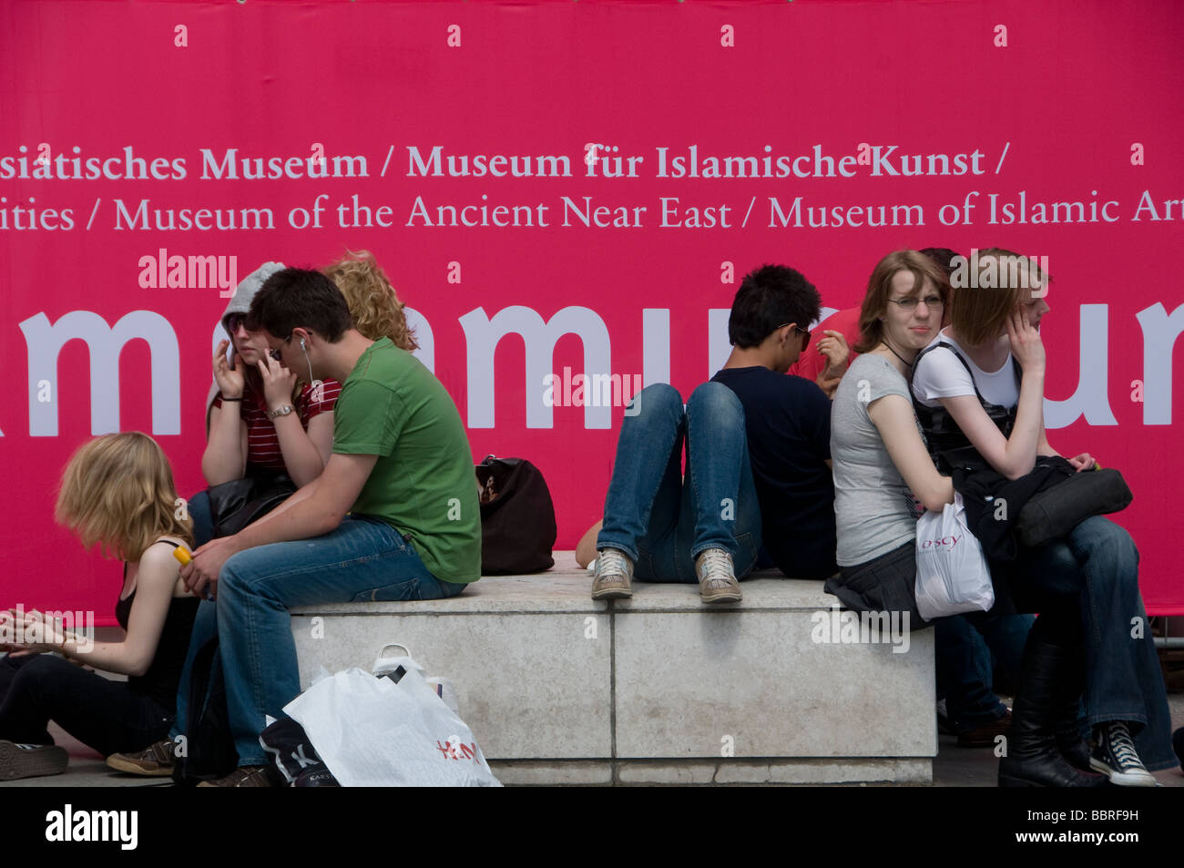 Junge Besucher, die sich vor dem Pergamonmuseum im Berliner Stadtteil Museumsinsel Mitte ausruhen Stockfoto