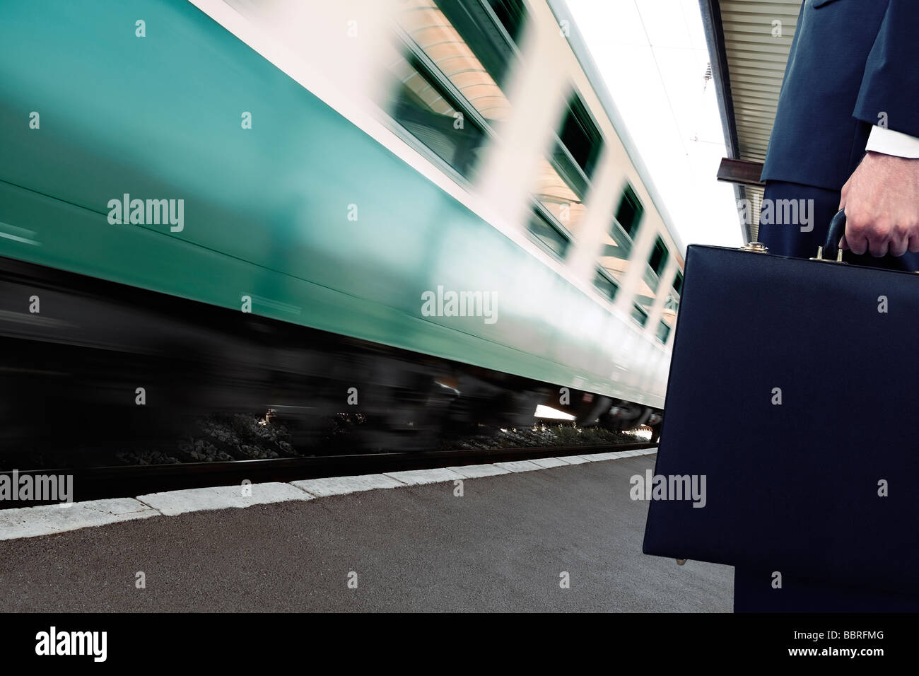 Pendler stehend auf einem Bahnsteig Bahnhof wie ein Zug vorbei an niedrigen Abschnitt geht Stockfoto