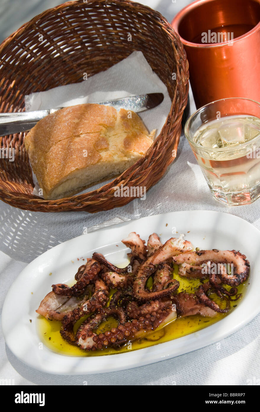 griechische Insel Taverne Restaurant Spezialität frische gegrillte marinierte Oktopus mit hausgemachten Wein und knusprigem Brot in Griechenland Stockfoto