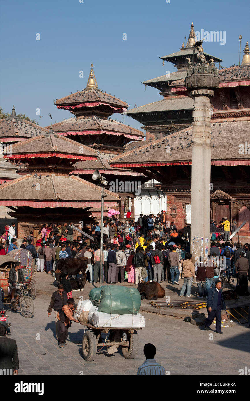 Kathmandu, Nepal. Durbar Square Menge eines Lautsprechers unter König Pratap Malla Spalte rechts von Jagannath Bügel hinter hören. Stockfoto