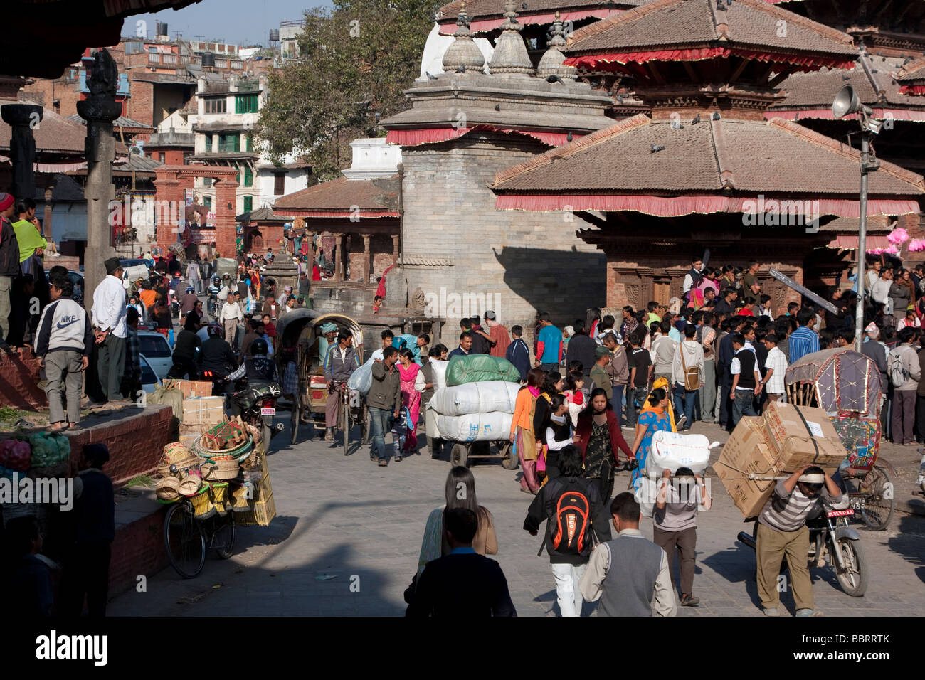 Kathmandu, Nepal.  Makkan Tole Straßenszene aus Durbar Square führt. Männer, die Güter transportieren. Stockfoto