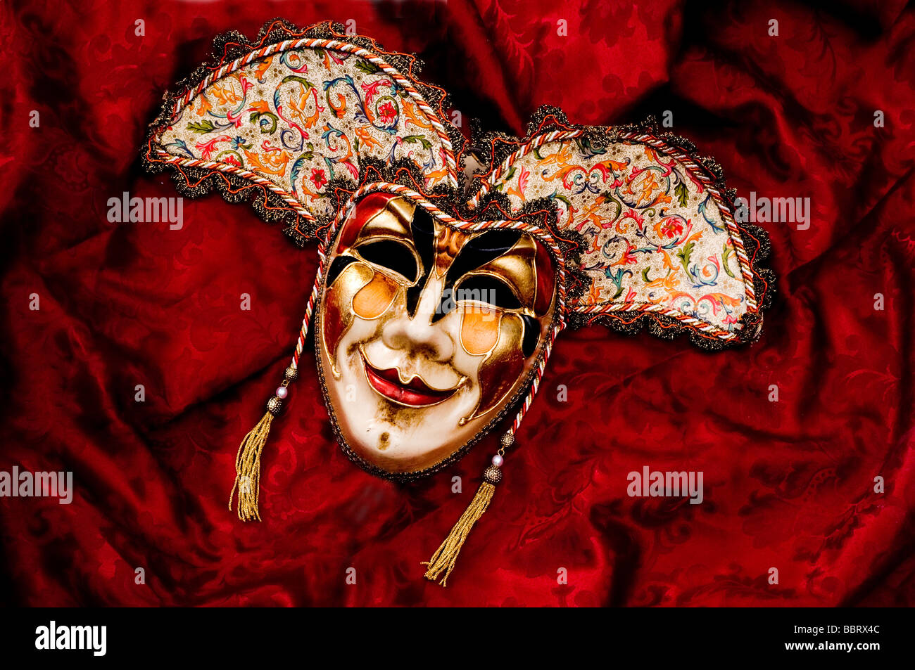 Venezianische Gesichtsmaske vor rotem Hintergrund Stockfoto