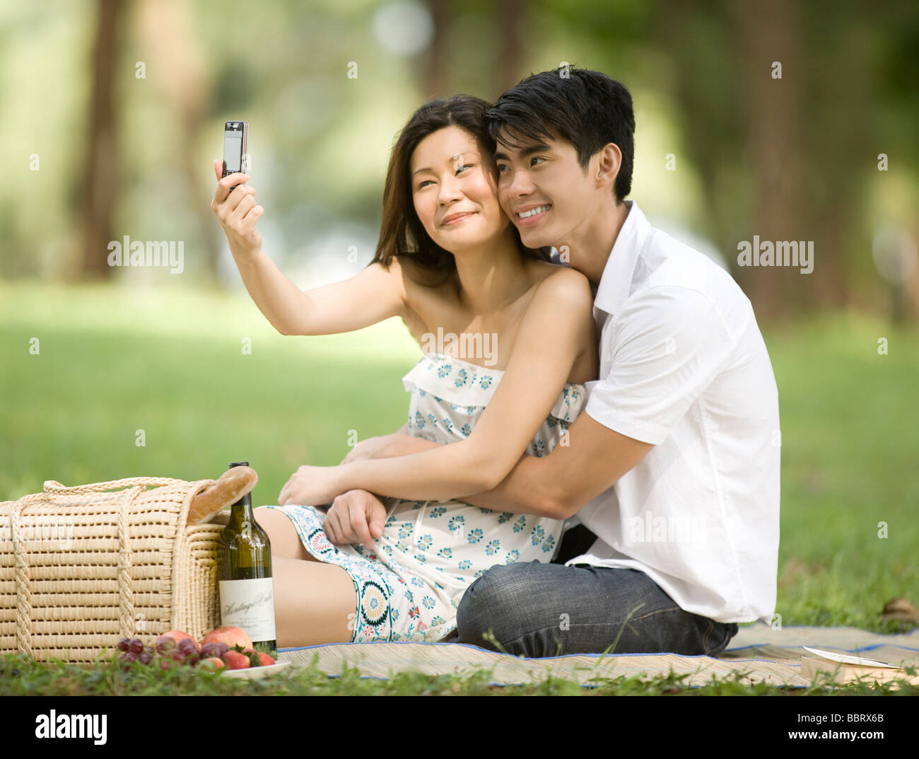 Junges Paar mit Picknick, Frau nehmen Foto mit Kamera-Handy Stockfoto