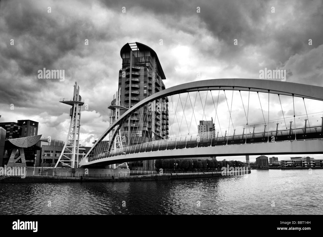 Heben Sie Brücke oder Millennium Fußgängerbrücke in Salford Quays, Manchester, England, mit Blick auf die Lowry Theatre und Outlet mall Stockfoto