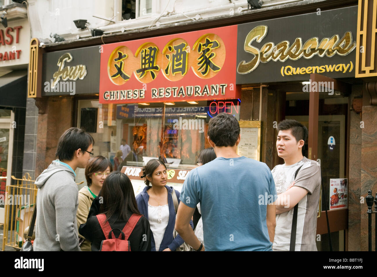 Jugendliche treffen vor einem chinesischen Restaurant in der Gerrard Street, Chinatown, London, UK Stockfoto