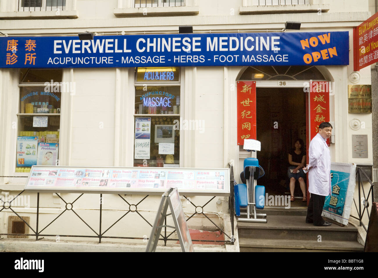 Ein chinesischer Arzt wartet draußen seine Operation, Gerrard Street, Chinatown, London, UK Stockfoto