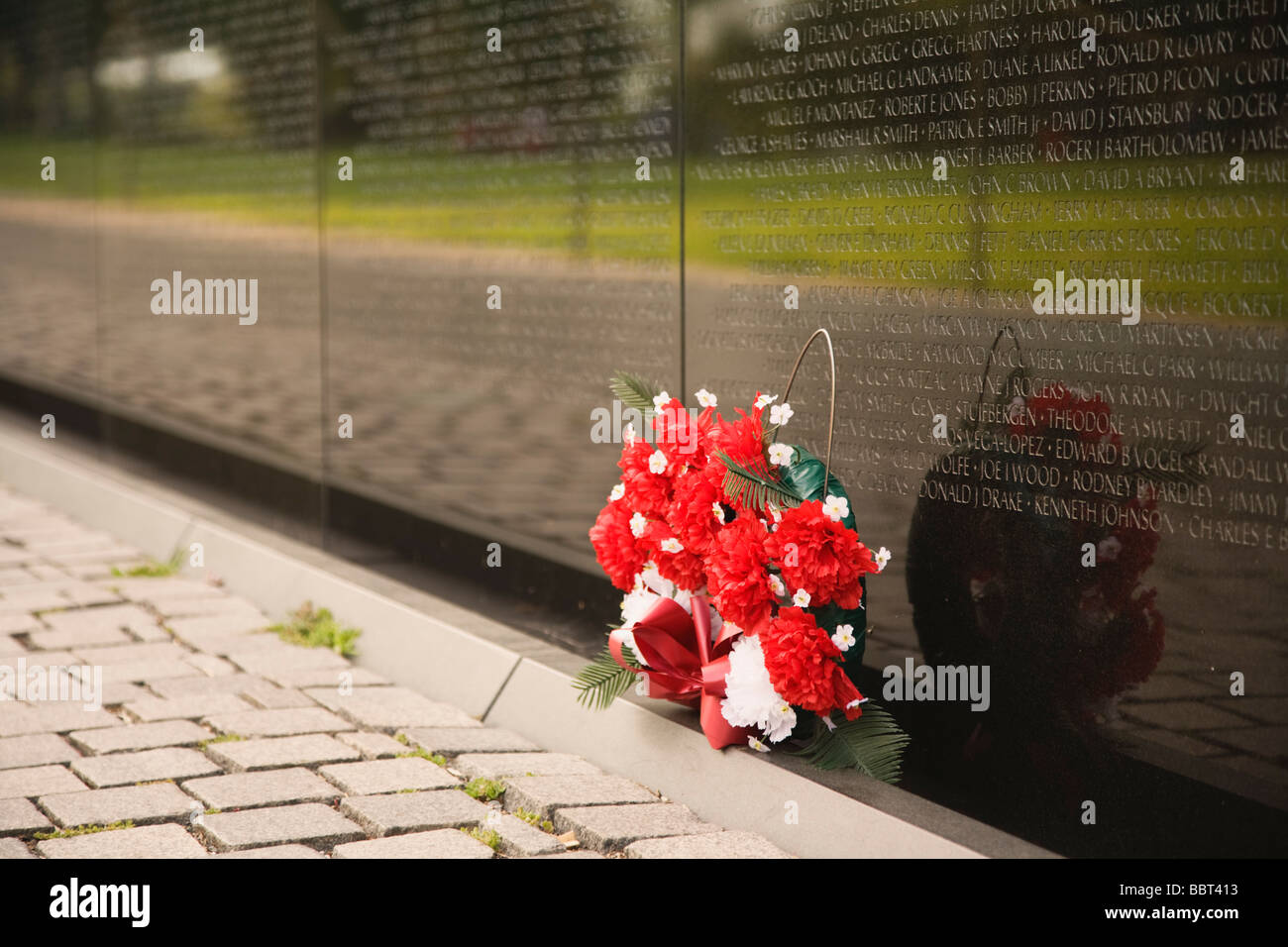 Ein Blumenstrauss links an der Vietnam Veterans Memorial Wall Washington DC USA Stockfoto