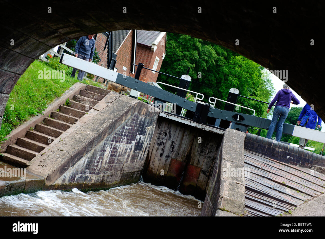 Die Besatzung von einem Lastkahn verhandeln ihren Weg durch die Tore im Tyrley werden auf der Shropshire-Union-Kanal gesperrt Stockfoto