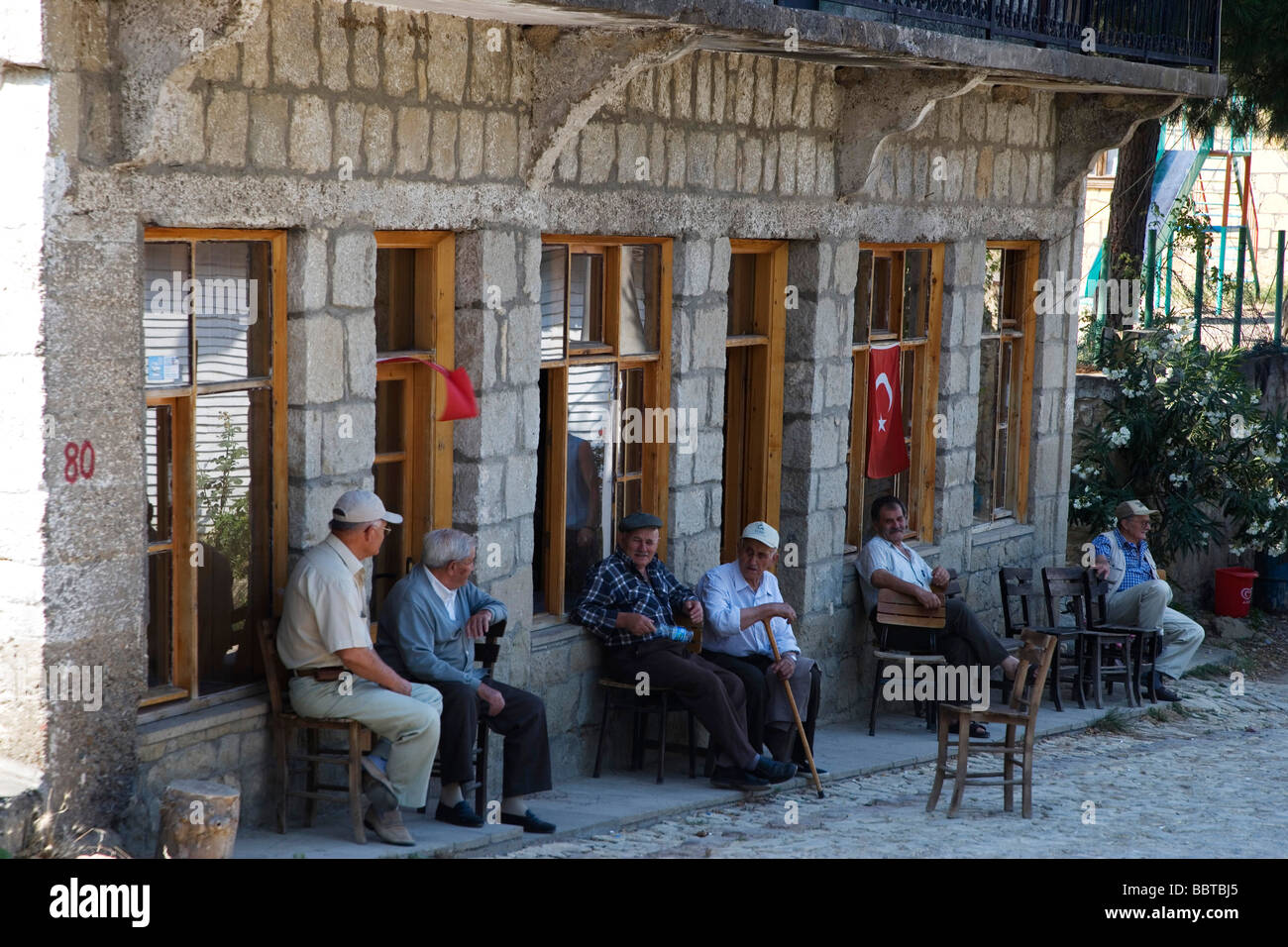 Menschen vor Ort haben eine Siesta auf dem Hauptplatz des Dorfes, Yesiliurt, Assos, Türkei, Europa Stockfoto