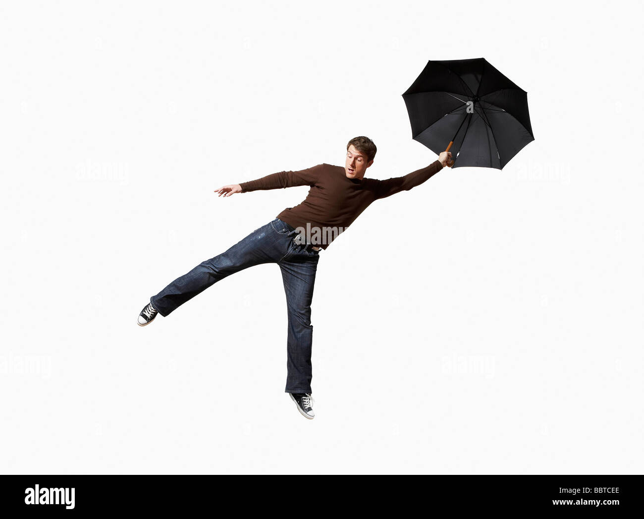 Mann mit Regenschirm wie weggeblasen Stockfoto