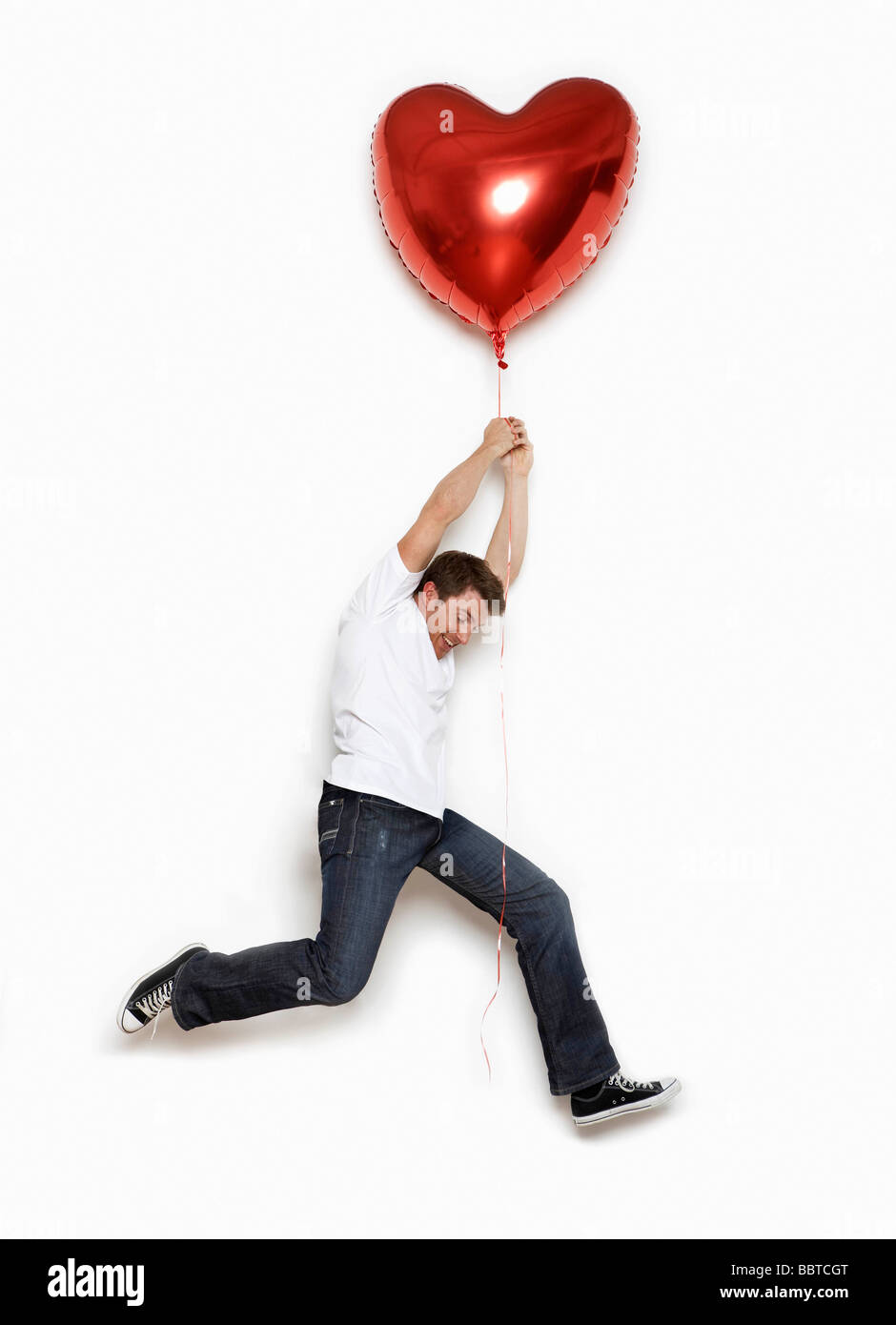 Mann von Herzballon gehoben Stockfoto